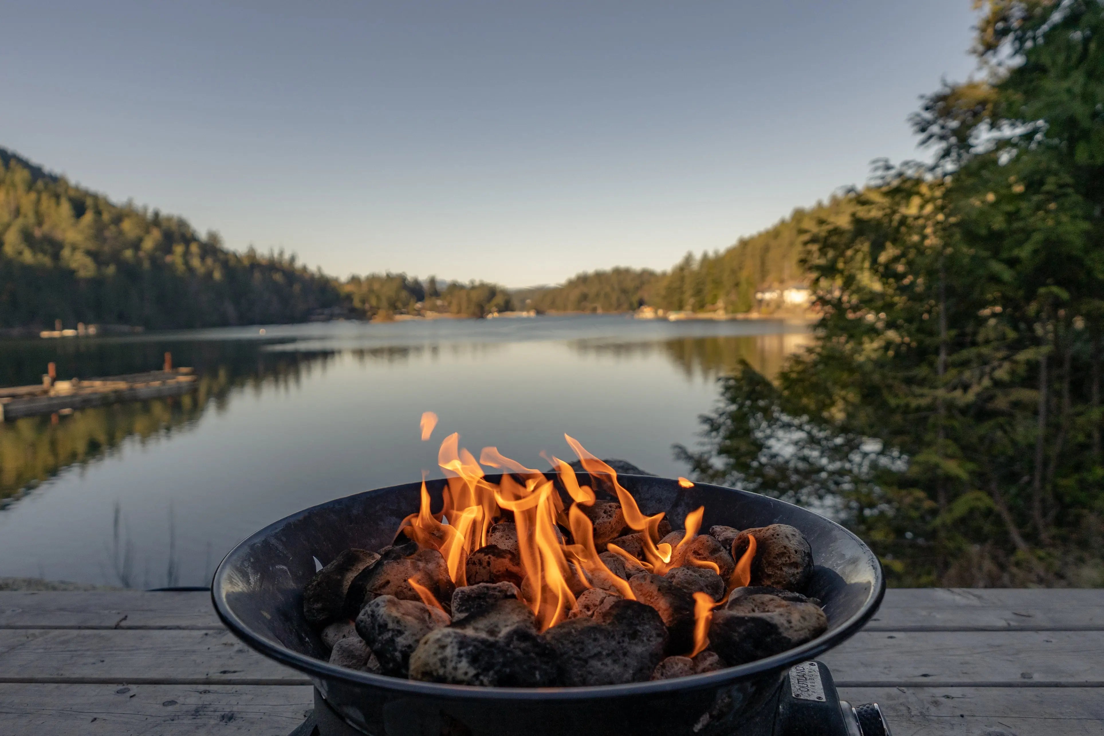 A charcoal fire burning in a basin placed by the riverside.
