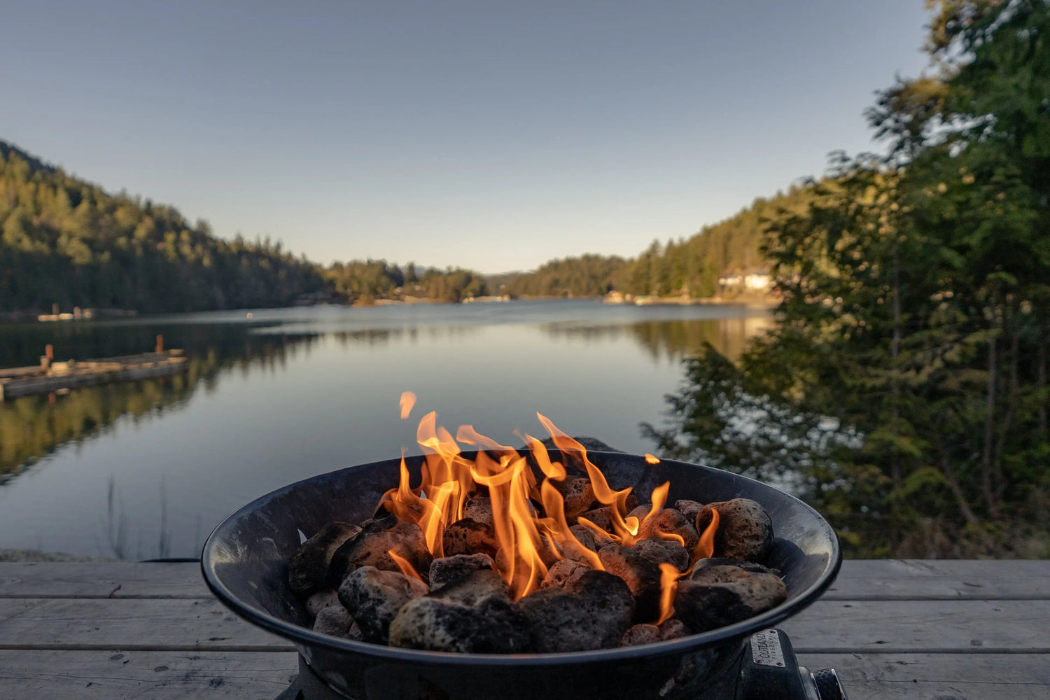 A charcoal fire burning in a basin placed by the riverside.